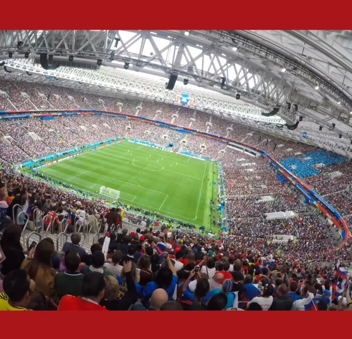 Estadio de fútbol lleno con la bandera de España al fondo