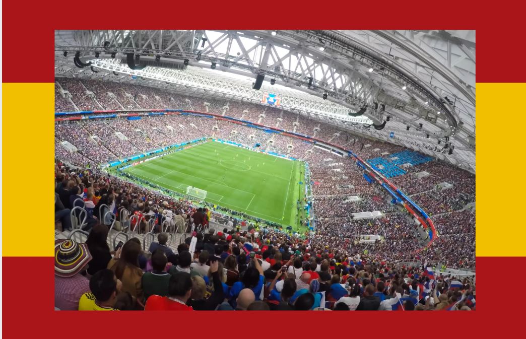 Estadio de fútbol lleno con la bandera de España al fondo